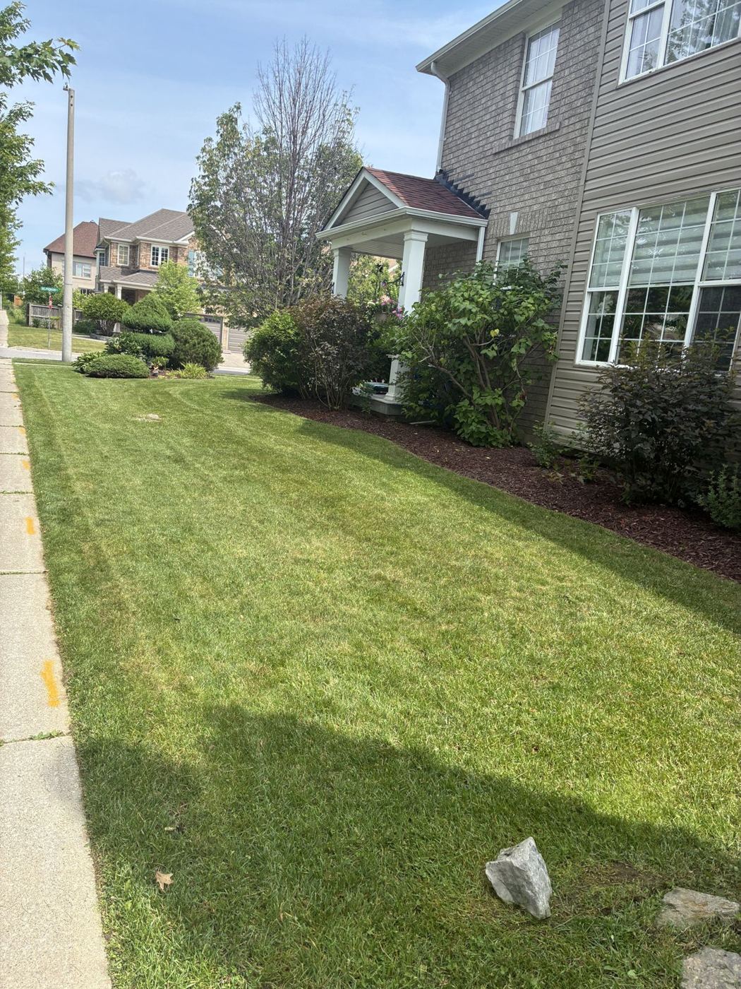 Sharply edged front lawn and garden bed line along a walkway